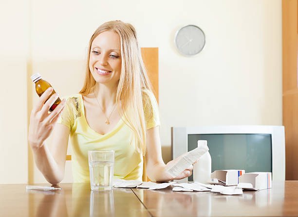 donna con farmaci al tavolo - medicinefever foto e immagini stock