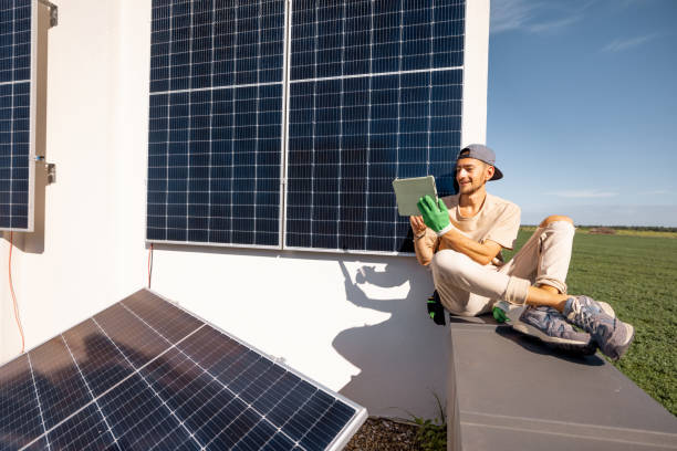 istock Man sitting on a rooftop with solar panels and using digital tablet 1741116977