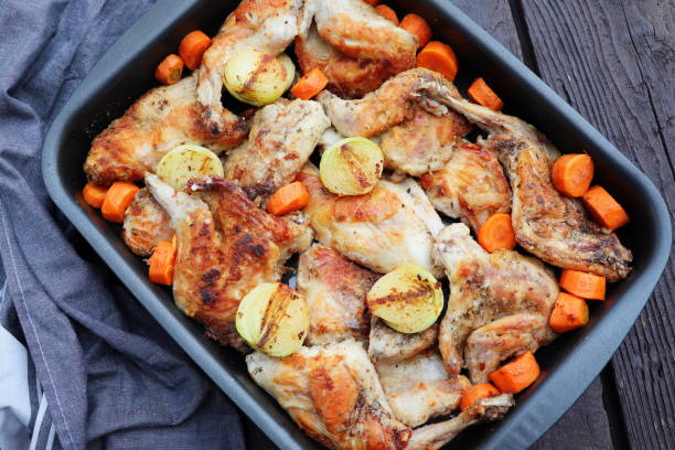 istock Roasted Rabbit Haunches in Pan with Stewed Vegetables on Rustic Wooden Table Surface 1741135489