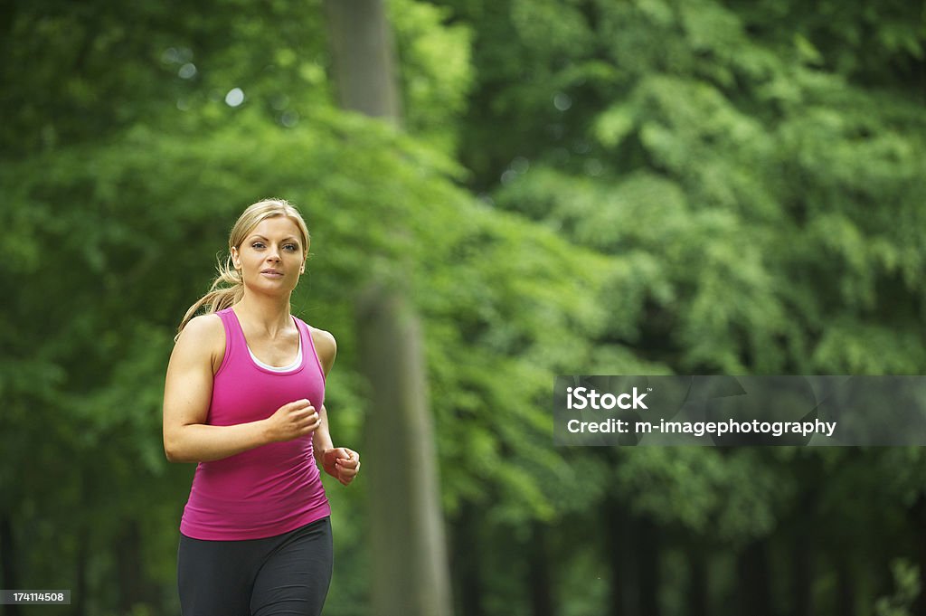 Young woman running in the park at her leisure Portrait of a young woman running in the park at her leisure 20-24 Years Stock Photo