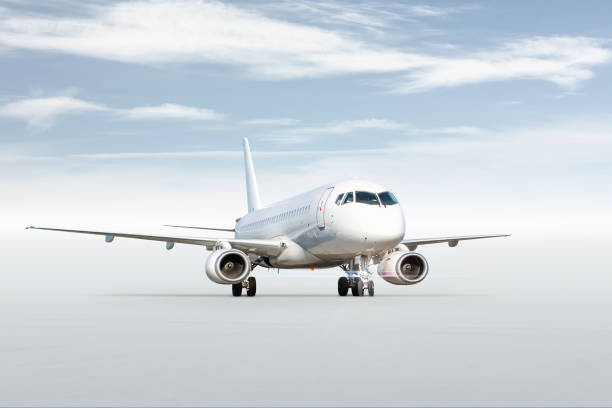istock White passenger airliner isolated on bright background with sky 1741149999