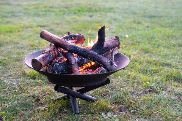 Stoking Logs On A Flaming Fire against black background