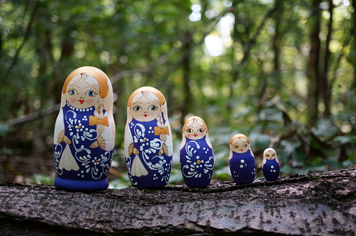 Figurines of beautiful dolls in the forest. Matryoshka dolls.