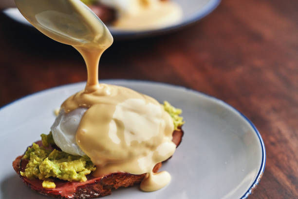 Poached Egg on Brown Bread Served with Ham, Avocado and Sauce Hollandaise