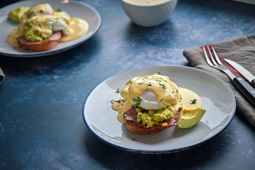 Poached Egg on Brown Bread Served with Ham, Avocado and Sauce Hollandaise