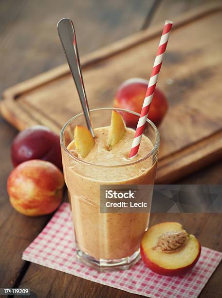 A Peach Smoothie With A Red Stripy Straw Stock Photo - Download Image Now - Peach, Milkshake, Smoothie