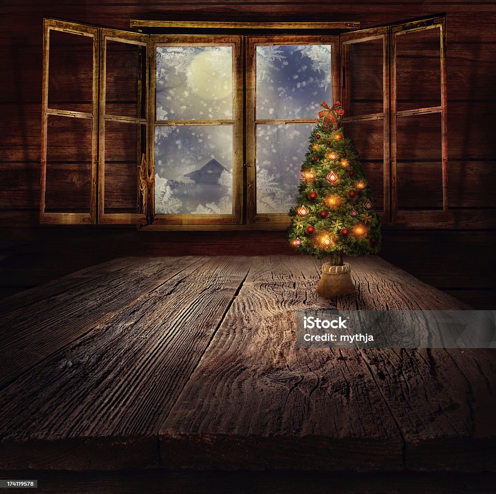 Christmas tree Xmas winter background in wooden cabin with Christmas tree and window with winter night in the background. Snow Stock Photo