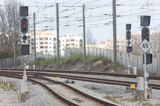 Railway tracks, electrical wires and traffic lights controlling traffic. Mid shot