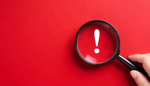 istock Magnifying glass and exclamation mark on red background 1741203486