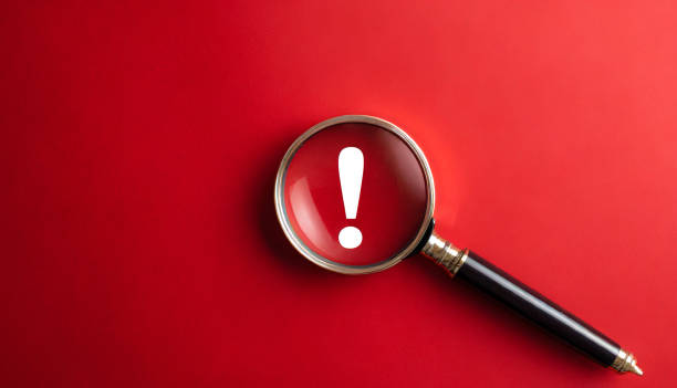 istock Magnifying glass and exclamation mark on red background 1741203493