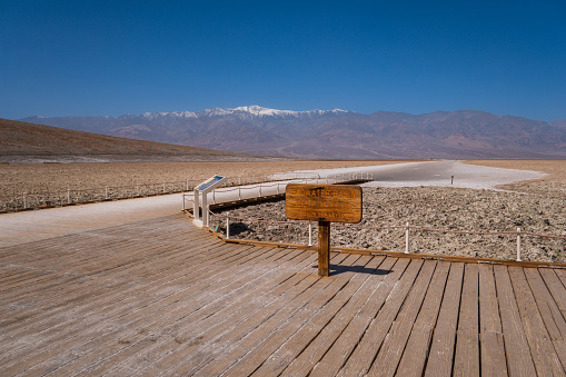 The lowest point of Badwater basin, Death Valley, USA. The sign post of Badwater basin at the start of the trail towards the salt flat.