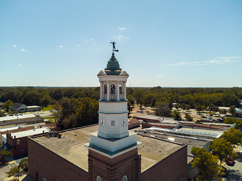 Camden Clock Tower rise above rooftops on the Broad Street in Camden, South Carolina. Aerial view
