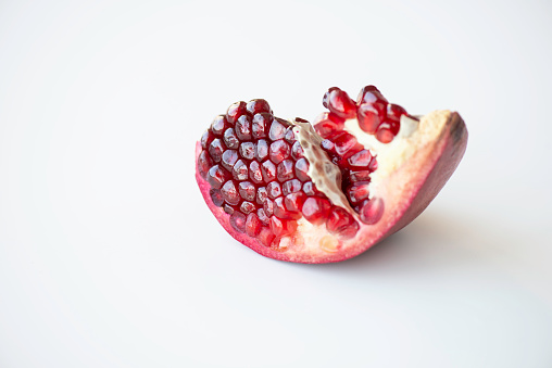 Fresh pomegranate creative layout on bright background. Healthy eating and dieting food concept. Winter fruits and berries composition. Top view, flat lay, design elements