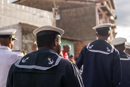 Saubara, Bahia, Brazil - August 06, 2022: Men from a Marujada, dressed as sailors, are seen parading through the streets of the city of Saubara, in Bahia.