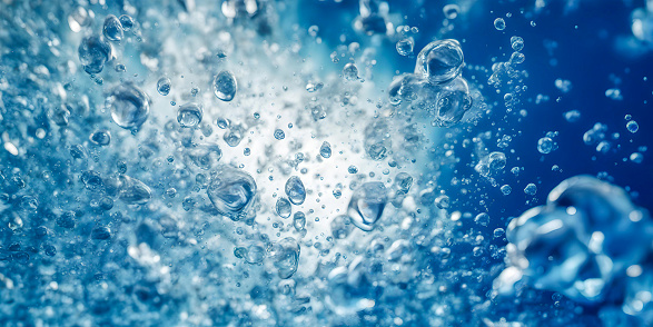 Close-up of air bubbles on water surface against black background.