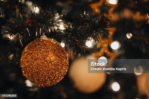 Details Of Christmas Ball With Golden Glitter Hanging On The Christmas Tree Branches Stock Photo - Download Image Now