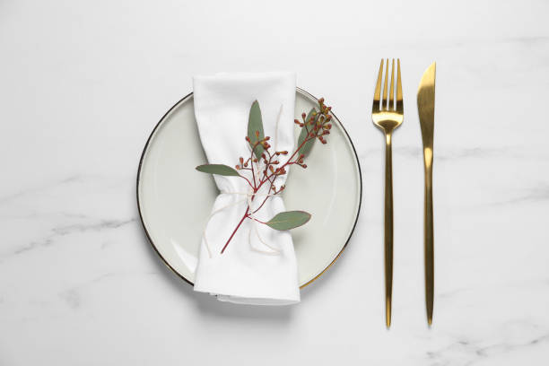 istock Stylish setting with cutlery and eucalyptus leaves on white marble table, flat lay 1741334603