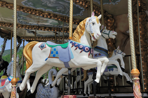 Colorful horses as part of a vintage merry-go-round for children on a playground