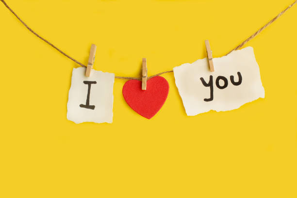 istock I love You phrase Made with texto and a red hearts hanging from a thread on a yellow background 1741380054