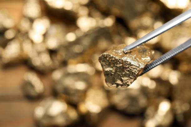 pinzas con pepita de oro sobre fondo borroso, primer plano. espacio para el texto - metal ore mineral stone block fotografías e imágenes de stock