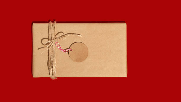 istock Gift box or present wrapped in craft paper with tag or label. Christmas present. Copy space. Mockup. Flat lay 1741401774