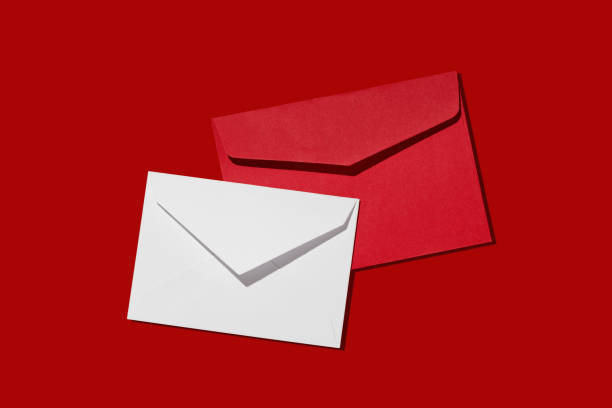 istock Red and white paper envelope on red background, top view 1741401784