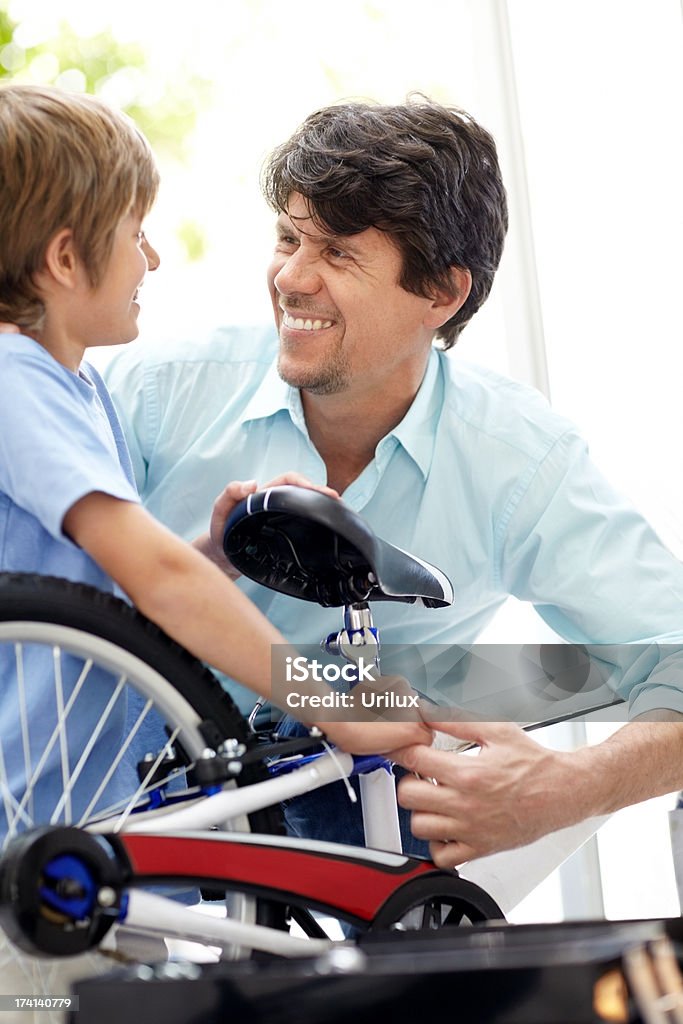 Young man repairing bicylcle for his son  Adult Stock Photo