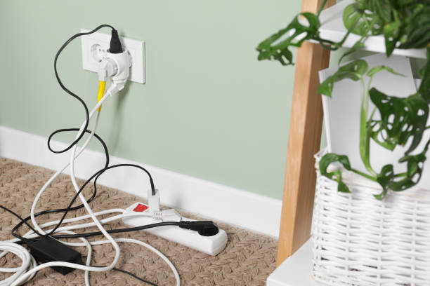 istock Different electrical plugs in socket and power strip on floor indoors 1741408567