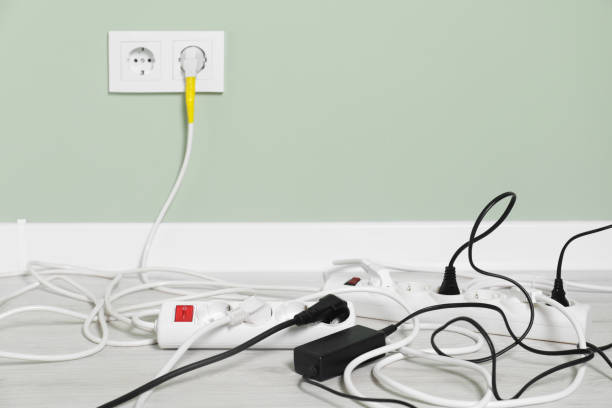 istock Power strips with different electrical plugs on floor indoors, space for text 1741409098