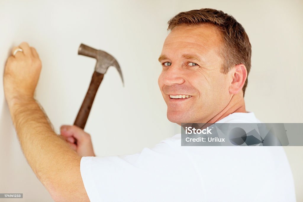 Smiling Man Hitting A Nail Into A Wall Using A Hammer Hình ảnh Sẵn có - Tải  xuống Hình ảnh Ngay bây giờ - iStock
