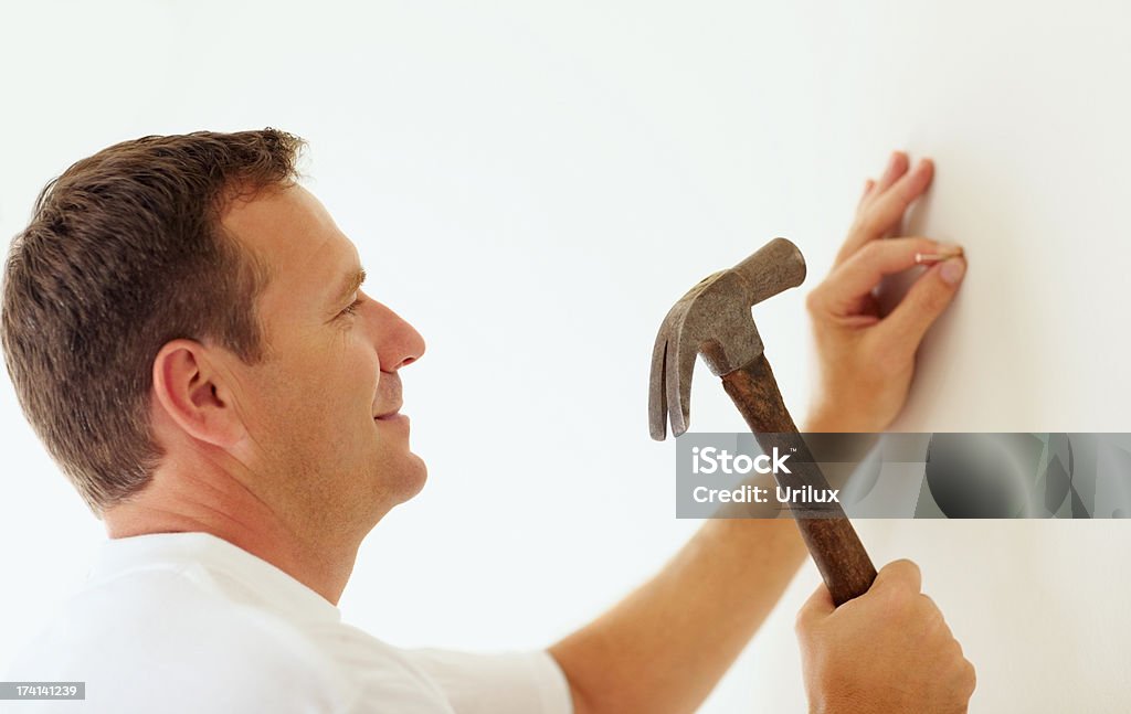 Smiling Mature Man Hammering A Nail Into A Wall Stock Photo - Download Image Now - Hammer, Nail - Work Tool, Men - iStock Smiling Mature Man Hammering A Nail Into A Wall Stock Photo - Download Image Now - Hammer, Nail - Work Tool, Men - iStock