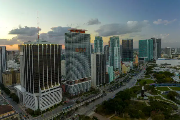 Aerial view of downtown district of of Miami Brickell in Florida, USA at sunset. High skyscraper buildings and street with cars and Metrorail traffic in modern american midtown.