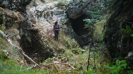 A female Asian solo traveler and hiker is hiking in extreme terrains in a mountain in nature.