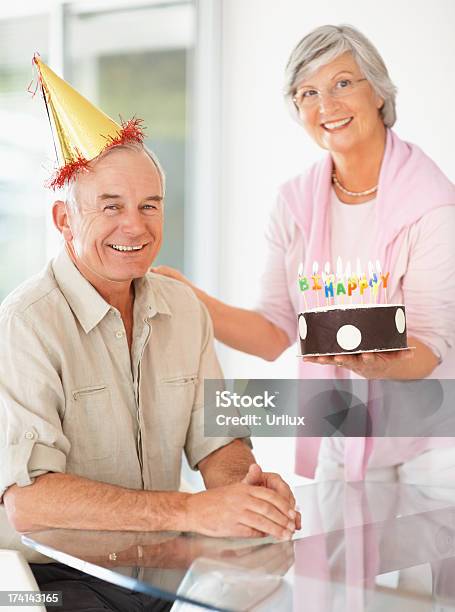 Senior Woman Celebrating Husbands Birthday With A Cake Stock Photo - Download Image Now