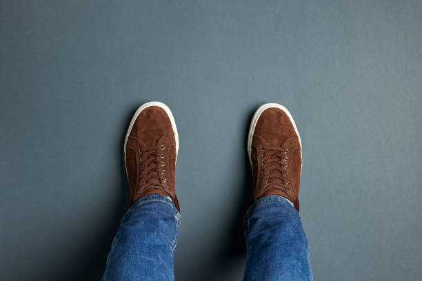 istock Man in stylish sneakers standing on grey background, top view 1741435488