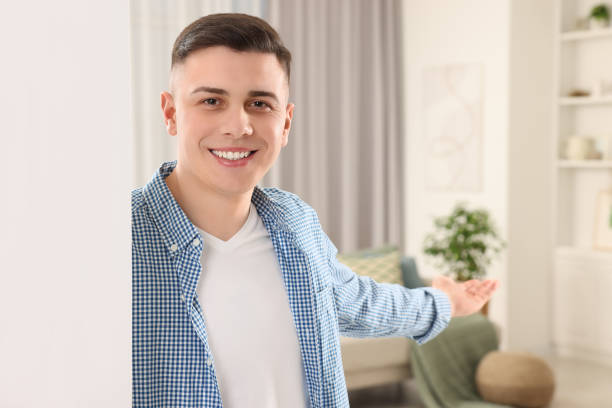 istock Handsome man inviting to come in room at home 1741436561