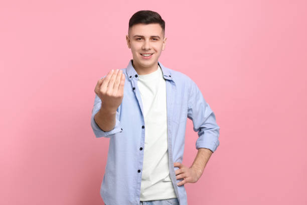 istock Handsome man inviting to come in against pink background 1741437791