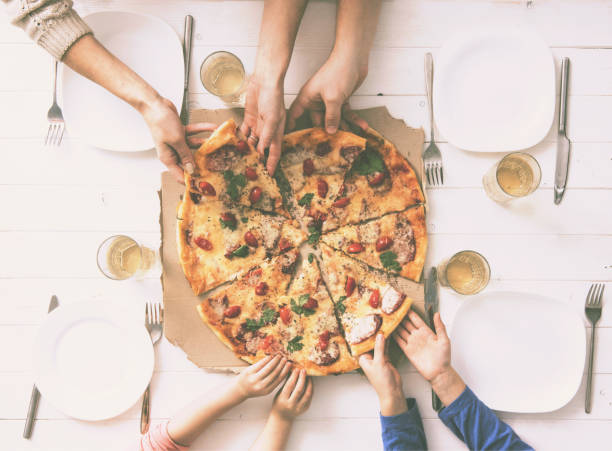 istock four hands taking pieces of pizza 1741449796