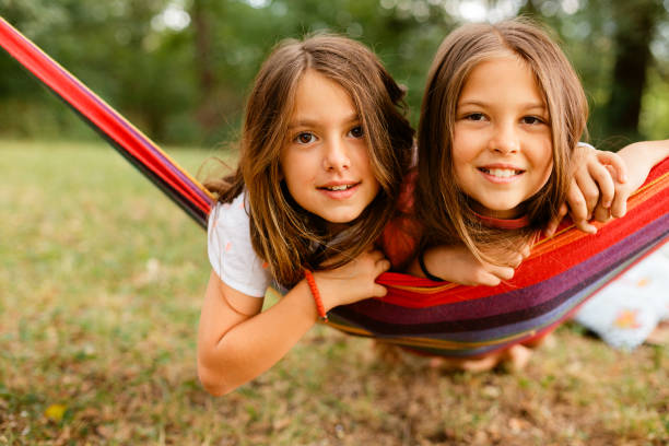 istock Two girls smiling while resting in the hammock in the yard 1741458144