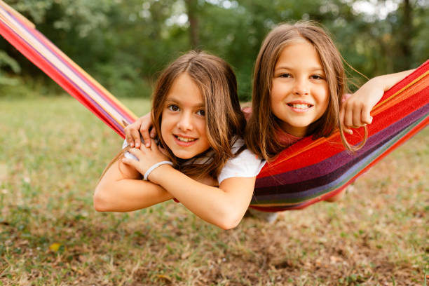 istock Two girls smiling while resting in the hammock in the yard 1741458153