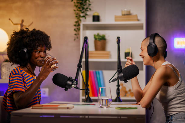 istock Two co-hosts are making a podcast in a home recording studio. It's a break time. 1741461777