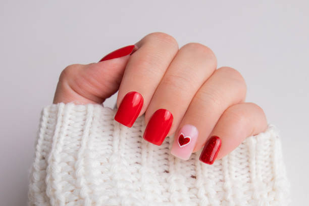 istock Female hand with red manicure nails, hearts design 1741495671