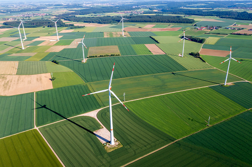 Aerial view of wind power station in a rural, spring landscape.