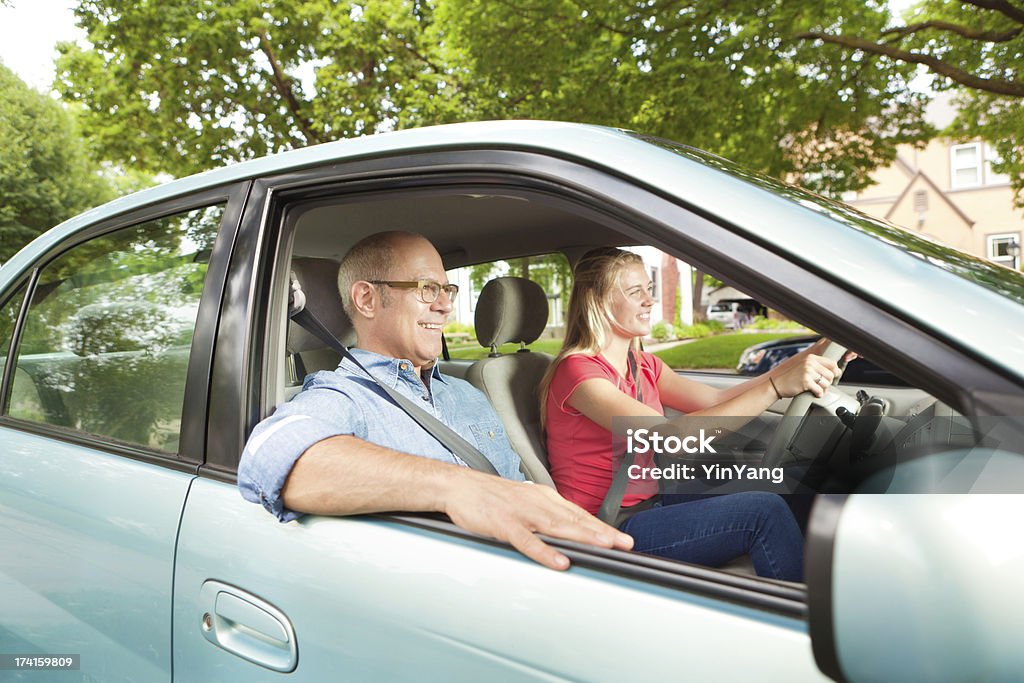Young Teen Driver Practicing Driving with Parent Subject: A happy young teen driving and learning to drive with parent supervising. Driving Stock Photo