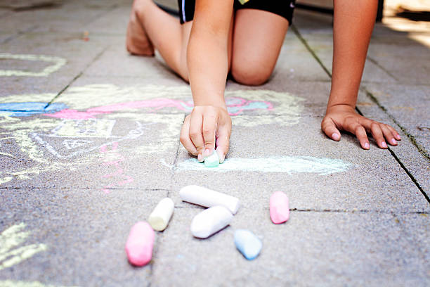 istock Little boy sitting on the pavement with colorful chalk 174159821
