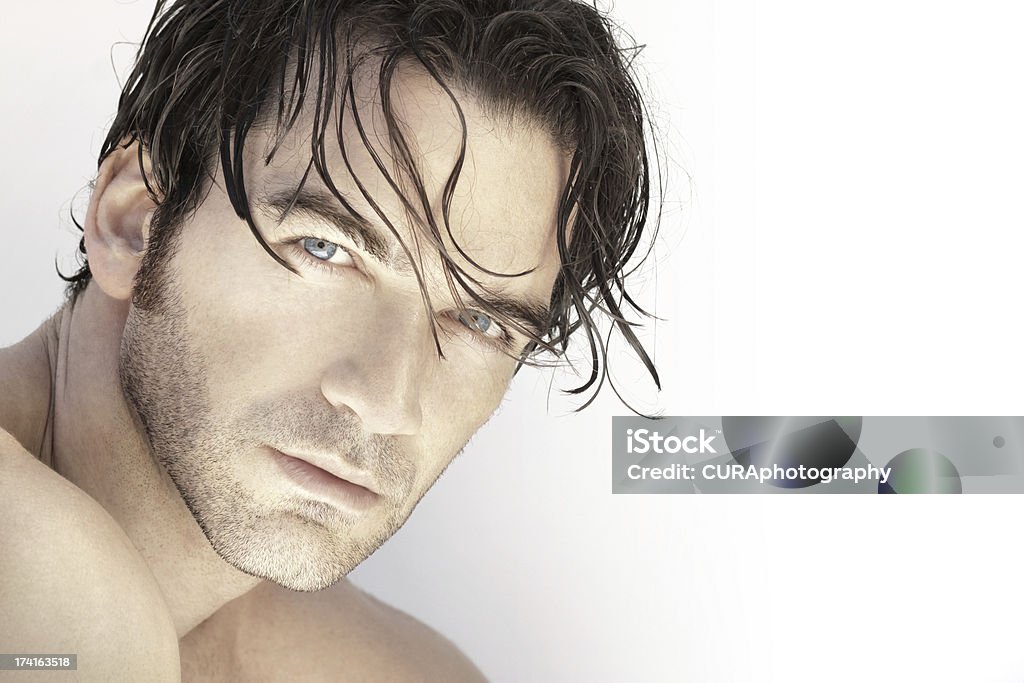 Handsome man up close Close up portrait of a beautiful sexy male model face against white background Men Stock Photo