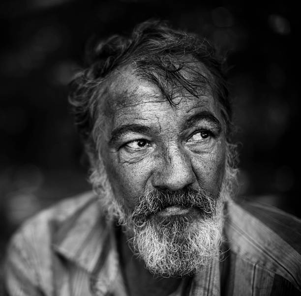 portrait of hobo real homeless man on the dark background, selective focus on eye homeless person stock pictures, royalty-free photos & images