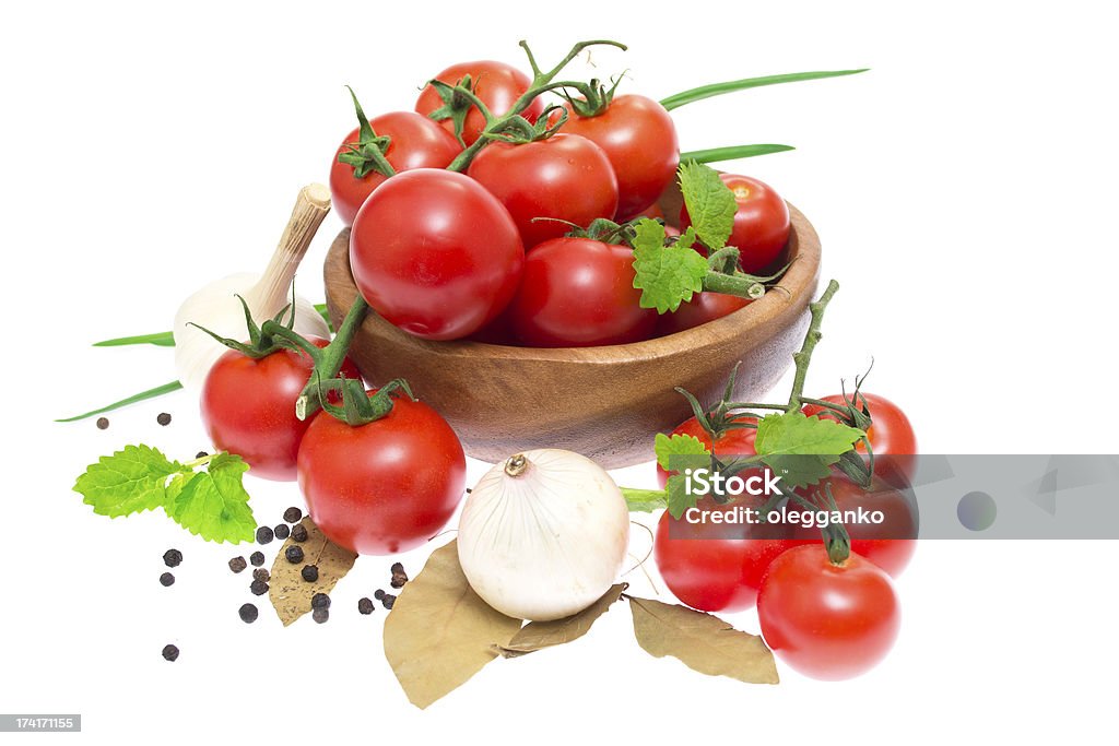 La succursale de tomates cerises dans un bol en bois - Photo de Ail - Légume à bulbe libre de droits
