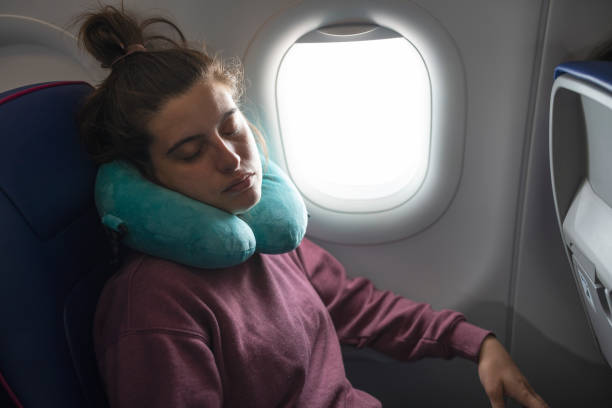 istock Woman on airplane sleeping while flying. 1741713979