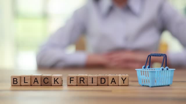 Female puts toy shopping basket on phrase Black Friday